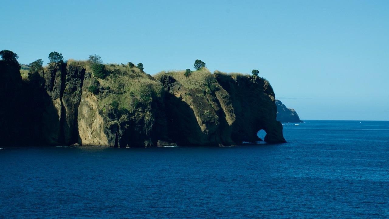 Volcanic sea cliff with a natural arch above the Atlantic Ocean in the Azores